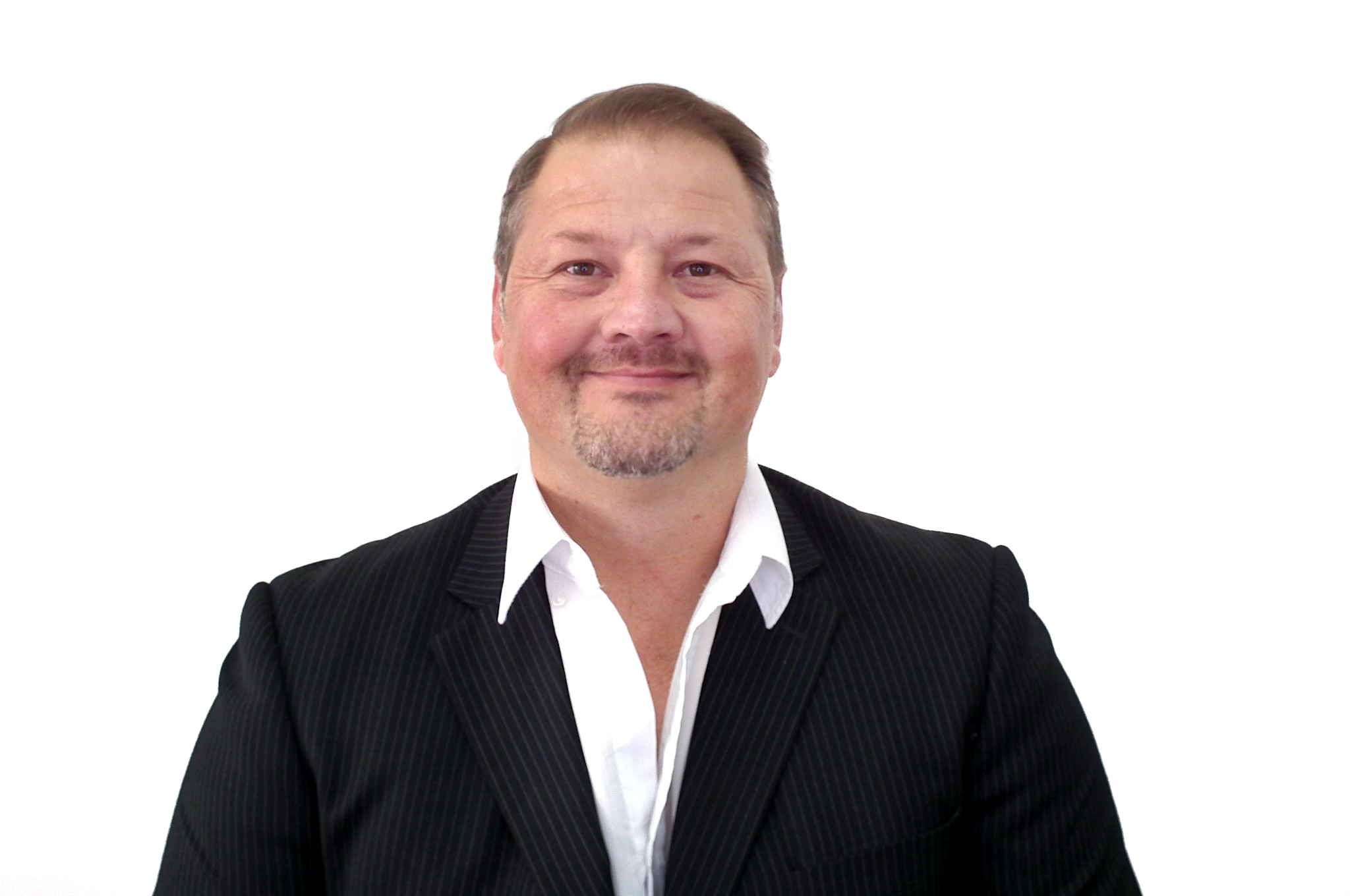 DSCF7021 ED Head-and-shoulders portrait of a smiling man in a dark pinstriped suit and white shirt against a white background.
