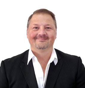 Smiling man in a dark pinstripe suit with a white shirt, head-and-shoulders portrait against a white background.